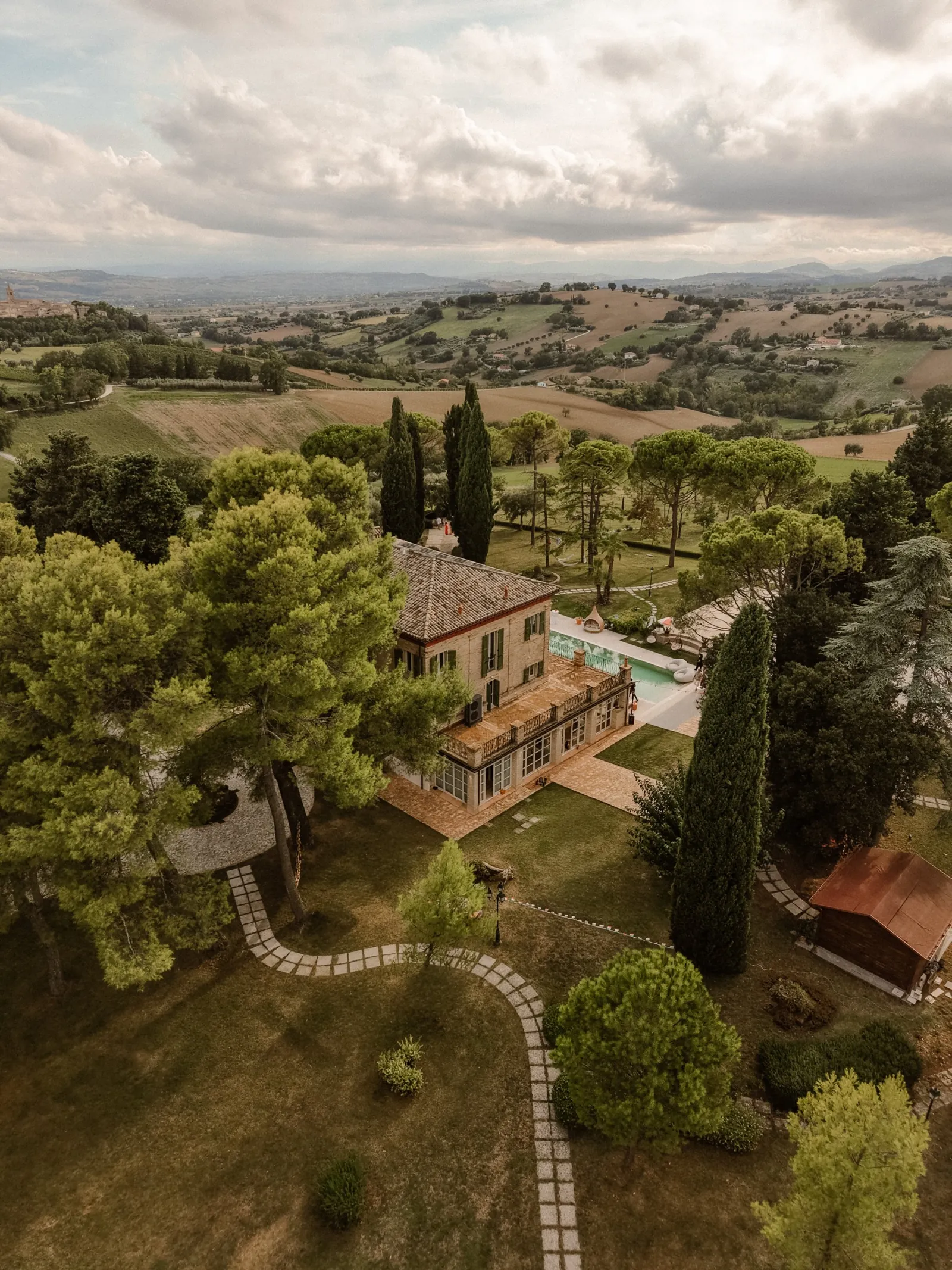 Drone view of the villa, pool and park with the hills of Le Marche behind